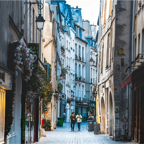 Explore the Marais district's winding streets packed with vintage shops and cafes, a twenty-minute walk away