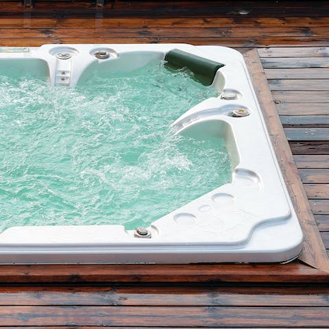 Unwind in the hot tub with a glass of bubbly