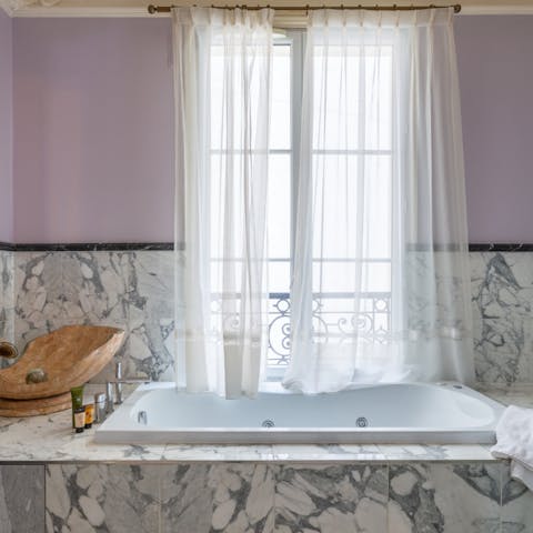 Relax in the lavish spa tub surrounded by marble