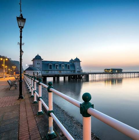 Walk less than fifteen minutes to Penarth Pier and watch the sun set over the water