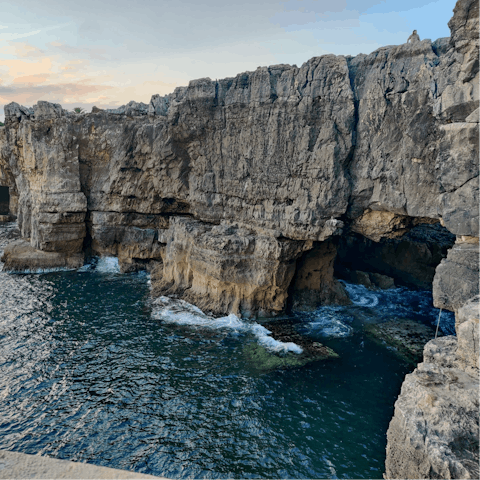 Watch the waves crash against the rocks at the Boca do Inferno