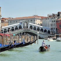 Cross the canal on the Rialto bridge