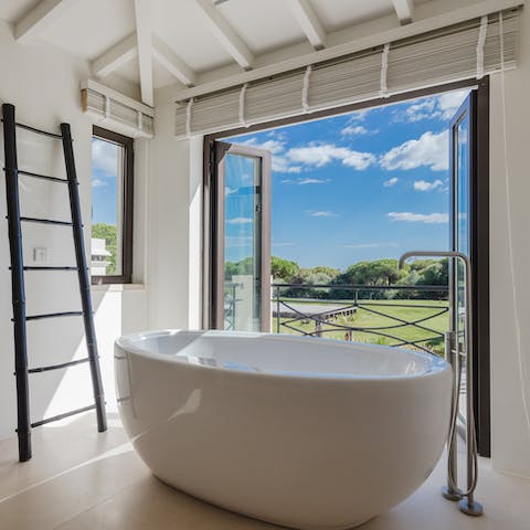 Soak in the slick roll-top bath while looking out to luscious garden views