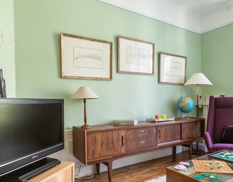 Unwind in the pastel green living room with vintage touches
