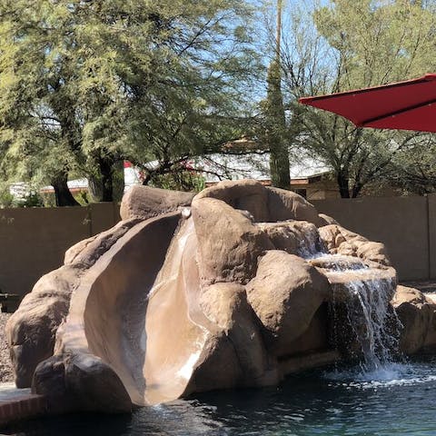 Slip down the built-in waterslide by the trickling waterfall
