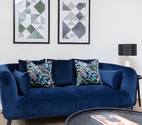 Sink into the plush blue velvet sofa as you show off your new purchases