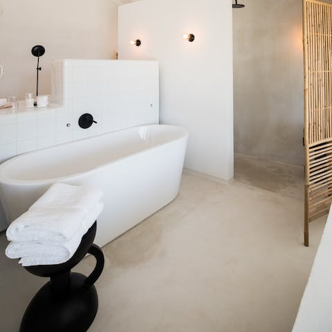 Treat yourself to a long and luxurious soak in the chic freestanding bathtub