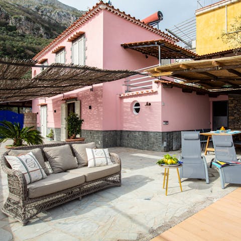 Take a seat on the outdoor sofa with a glass of wine in hand