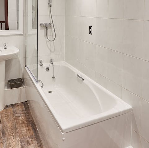 Treat yourself to a relaxing bubble bath in the sleek bathroom 