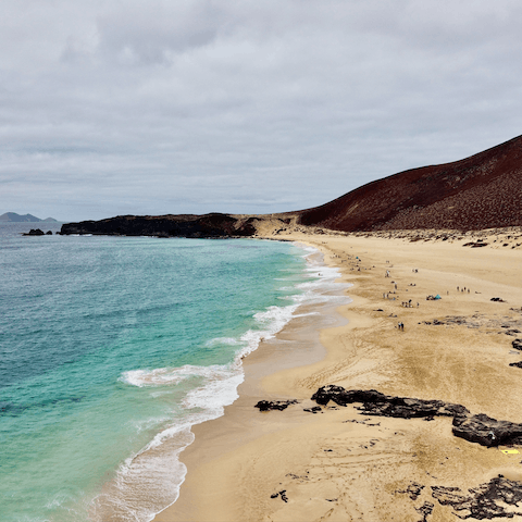 Walk or drive to the sandy and rocky beach of Playa Blanca