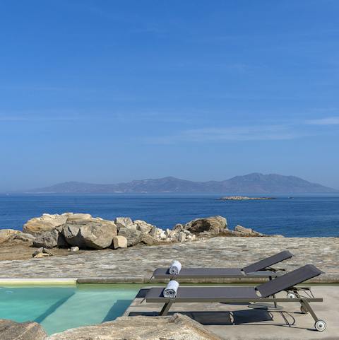Admire the rocky coastline of the Greek islands from the pool