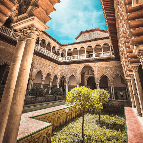 Visit the striking Royal Alcázar of Seville, around a fifteen-minute walk away