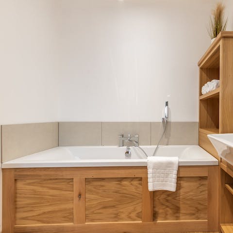 Treat yourself to a long soak in the handsome wood-panelled bathtub