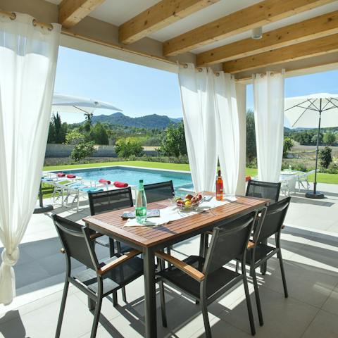 Dine poolside, watching as the sun begins to dip behind those majestic mountains