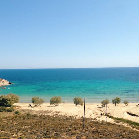 Sunbathe on Psarou Beach, just a twelve-minute walk away