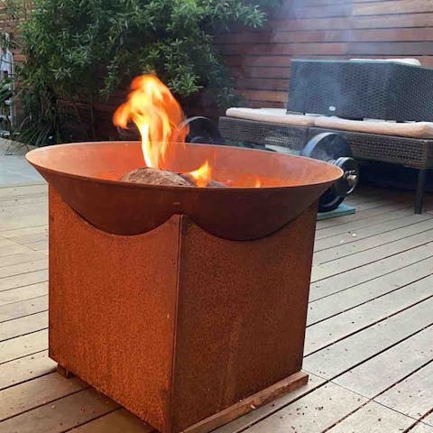 Gather around the corten steel fire pit with a glass of fizz