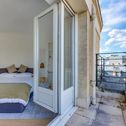 Open up the doors to the balcony and greet the Parisian rooftops from bed