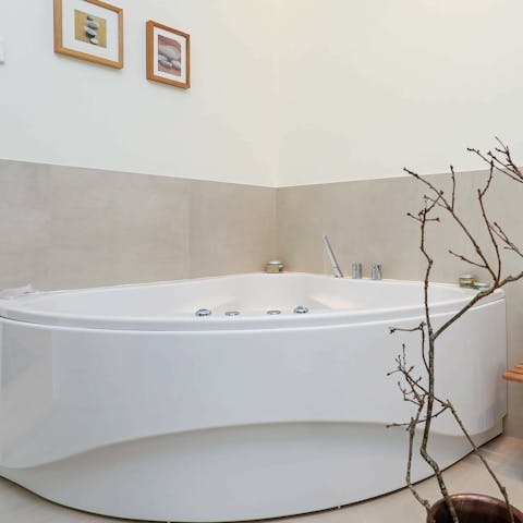 Relax your muscles in the Jacuzzi tub with a glass of champagne in hand