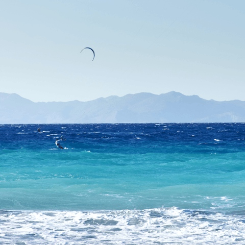 Try your hand at kite surfing on Kremasti Beach