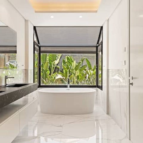 Relax in the freestanding bath with its views of lush banana plants