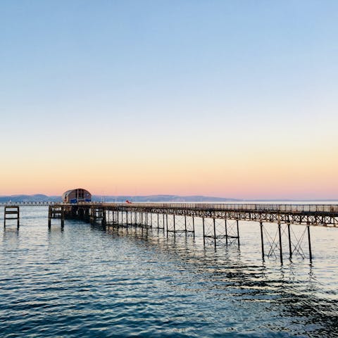 Take a bracing walk along the coastal path to visit the historic Mumbles Pier