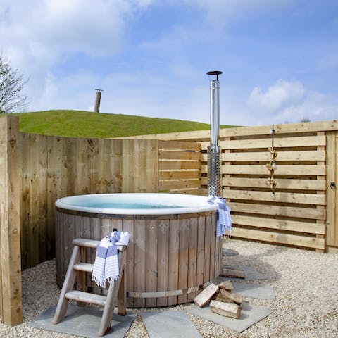 Slip into the wood-fired hot tub, allowing the water to relax you