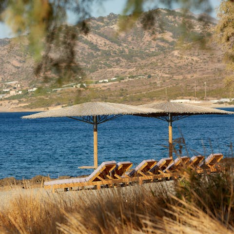 Stroll across the sand to the shared loungers at the water's edge