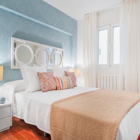 Get some rest in the bedroom with its soothing blue hues after a busy day exploring Madrid