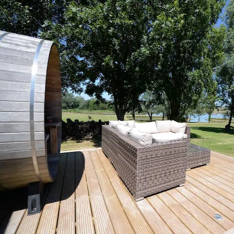 Shelter under the barrel sauna in the winter or relax on the cushions in the summer