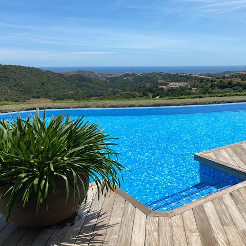 Slip into the infinity pool with a view of the mountains and sea
