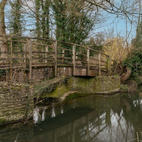 Stroll across the garden bridge as the mill waters rush by below