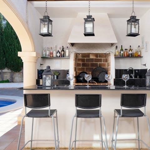 Enjoy a drink by the pool at the outdoor bar, perfect for staving off the Spanish heat