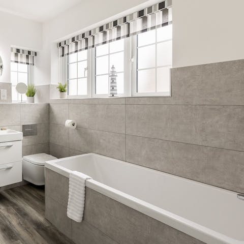 Treat yourself to an unrushed soak in the svelte grey bathtub