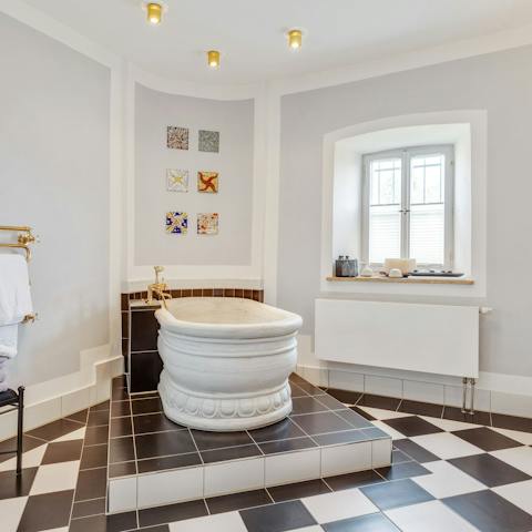Treat yourself to an indulgent soak in the marble-tiled bathroom