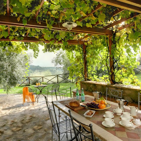 Dine alfresco beneath a vine-covered pergola offering perfect romance