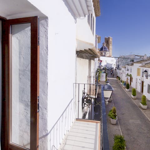 Step out onto the balcony and watch the world go by on the white-washed street below