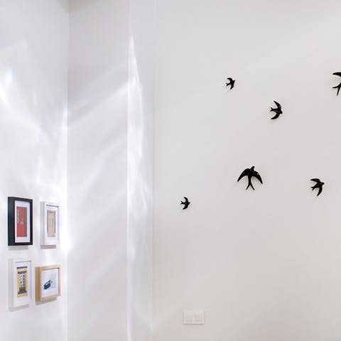Admire quirky wall decals and local artworks on the pristine white walls