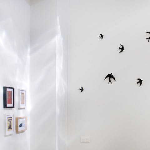 Admire quirky wall decals and local artworks on the pristine white walls