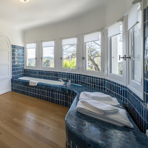 This blue tiled bathroom, with a view over the hills, is nothing short of spectacular