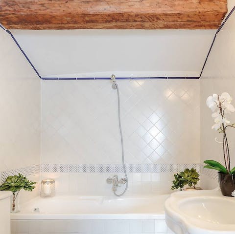 Soak in the tub beneath the original timber beams in the bathroom
