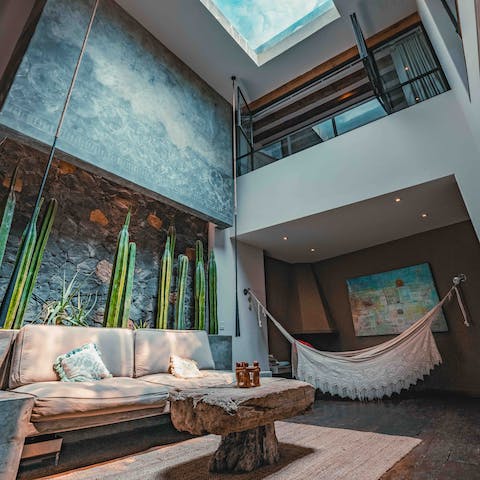 Take time to yourself in the zen living space with double-height ceilings and calming teal hues