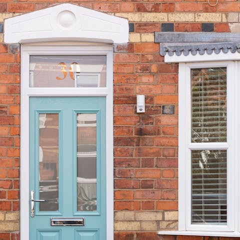 Arrive in style at the charming blue door and admire the red brickwork