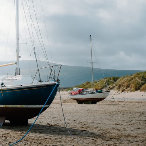 Enjoy a brisk stroll along Barmouth Beach, a twenty-minute drive away