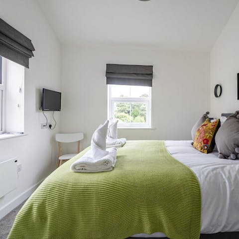 Wake up in this beautifully bright bedroom with leafy scenes from two windows