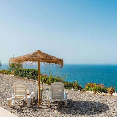 Grab a drink and admire the stunning ocean views from the sunloungers