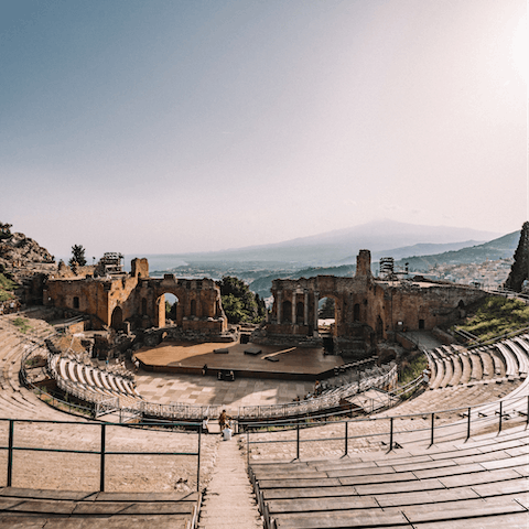 Sit in the breathtaking amphitheatre in Taormina, just an eleven-minute drive away