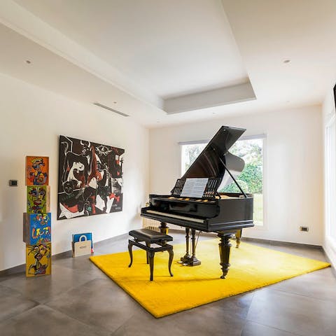Tickle the ivories of the grand piano, surrounded by art