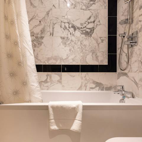 Soak in the tub all night, surrounded by luxurious marble tiles