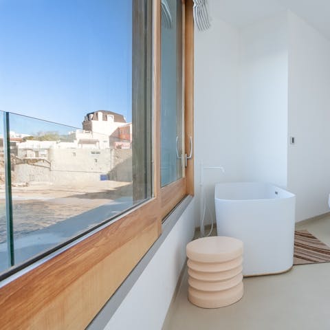 Soak away in your freestanding bathtub while you gaze out at views of the sea