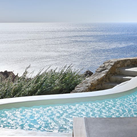 Float in the curvy swimming pool overlooking the Aegean Sea